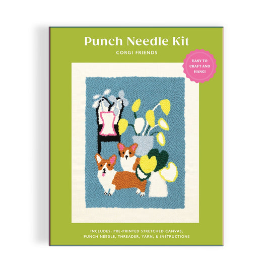 The Anne Bentley Corgi Friends Punch Needle Kit features a box with two corgis among potted plants on a blue background. Easy to craft and hang, this kit is perfect for beginners.