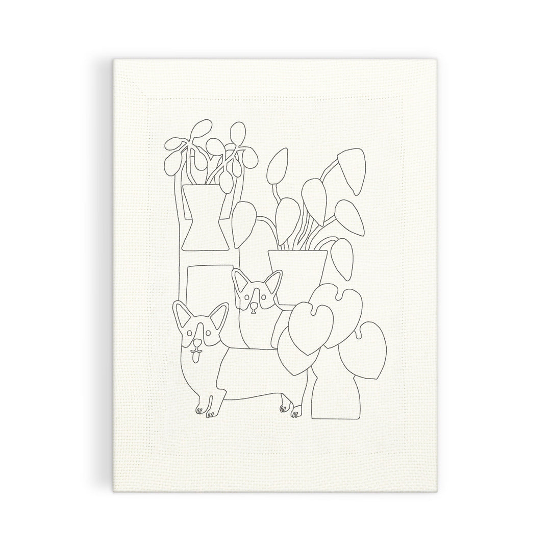 Create your own minimalist art with the Corgi Friends Punch Needle Kit by Anne Bentley, featuring two corgis among leafy potted plants on a textured white canvas.