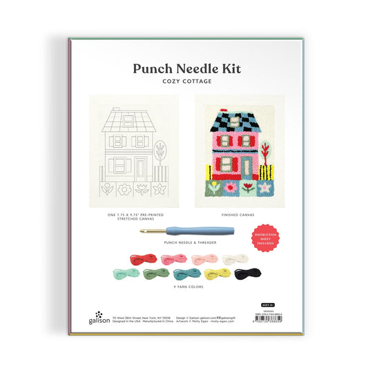 The Molly Egan Cozy Cottage Punch Needle Kit package displays a pre-printed canvas with a cottage outline, a completed colorful cottage canvas, a punch needle, threader, and nine yarn colors neatly arranged below.