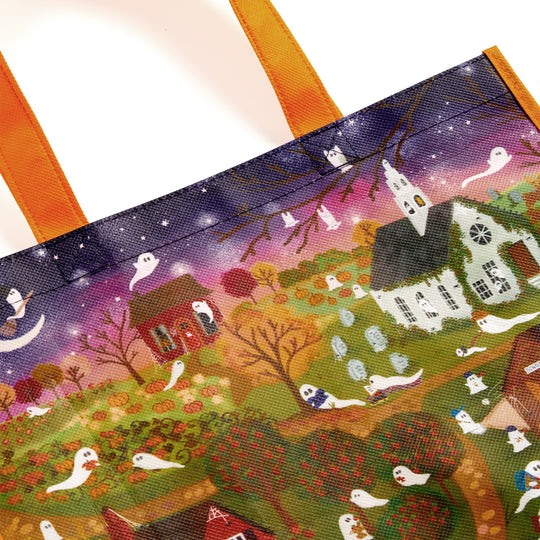 The Joy Laforme Spooky Village Reusable Shopping Bag by Joy Laforme showcases a whimsical Halloween village with ghosts, houses, fall trees, and a starry night sky. Bright orange handles make it ideal for eco-conscious shoppers.
