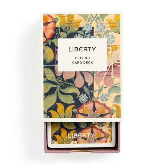 The Liberty Archive Playing Card Deck by Liberty London features vibrant floral patterns inspired by textile heritage on the packaging and card backs, with a white label on the front reading LIBERTY. PLAYING CARD DECK.