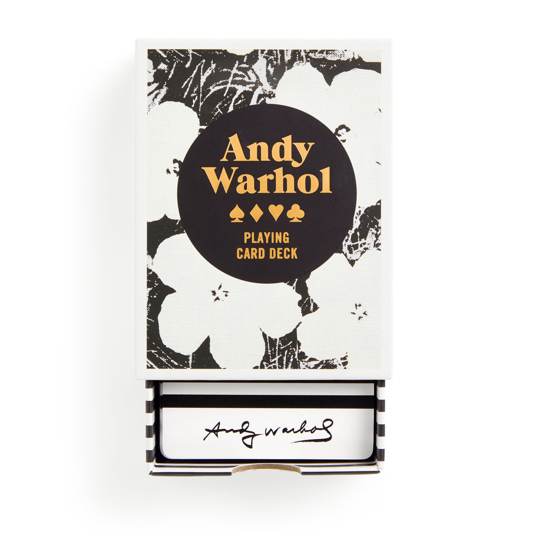 A deck of playing cards by the Andy Warhol Foundation for the Visual Arts, featuring black and white floral art, gold Warhol Pop Art Playing Card Deck text, premium cardstock, and Warhol’s signature inside the drawer box.