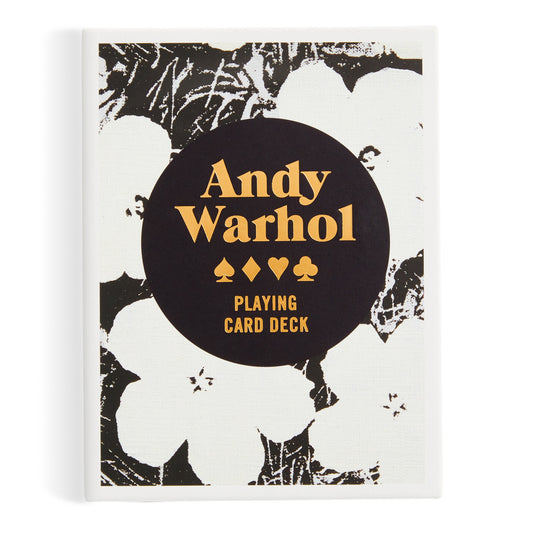 The Warhol Pop Art Playing Card Deck by the Andy Warhol Foundation For The Visual Arts features bold gold Andy Warhol Playing Card Deck lettering and card suits on a black circle, set against a black-and-white floral Warhol-inspired background.
