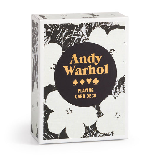 The Warhol Pop Art Playing Card Deck by Andy Warhol Foundation For The Visual Arts features bold yellow Andy Warhol lettering, suit symbols, and Playing Card Deck on a black circle over a white floral Pop Art-inspired background.