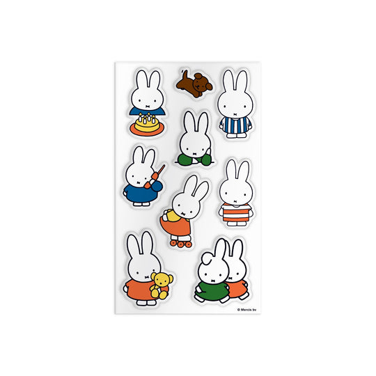 The Miffy Sticker Tin by Miffy includes stickers of the white bunny in different outfits and poses—eating cake, painting, skating, hugging a teddy bear, playing with another bunny—and a brown dog.