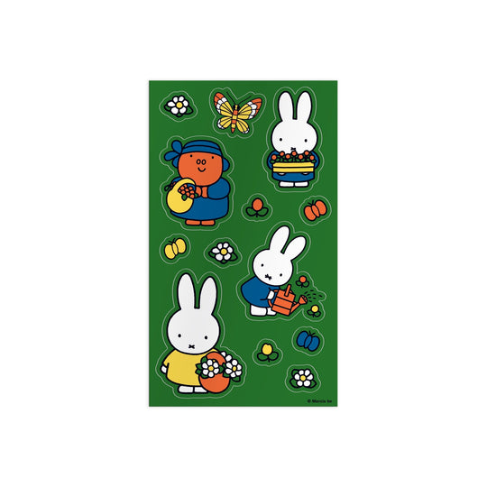 The Miffy Sticker Tin by Miffy features colorful stickers of cartoon rabbits in blue and yellow dresses, a rabbit watering flowers in a red pot, plus butterflies and bees all on a green background.