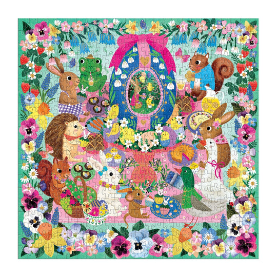 The Egg-cellent Day 500 Piece Foil Family Puzzle by Rebecca Jones showcases adorable rabbits, squirrels, a hedgehog, and a frog near a decorated egg and spring flowers, framed by a brilliant floral border.